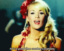 A Woman With A Red Flower In Her Hair Sings He 'S A Good Time Cowboy Casanova GIF