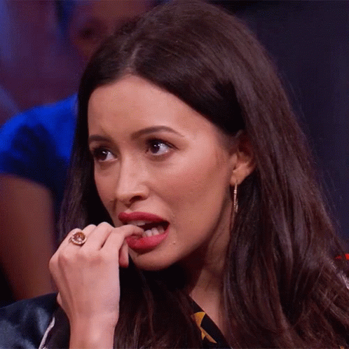 A Woman With A Ring On Her Finger Bites Her Finger GIF
