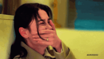 A Woman With A Ring On Her Finger Covers Her Mouth With Her Hand GIF