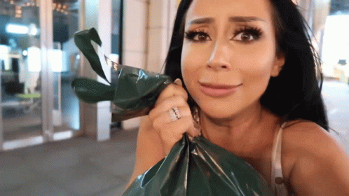 A Woman With A Ring On Her Finger Holds A Bag GIF