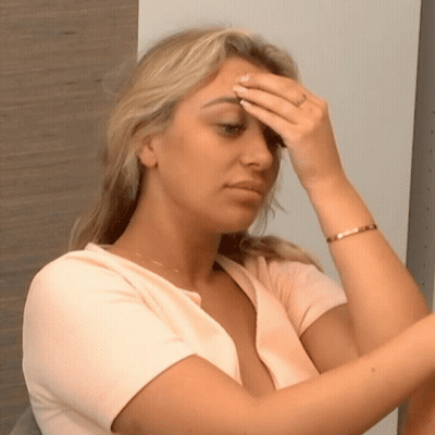 A Woman With A Ring On Her Finger Holds Her Head GIF