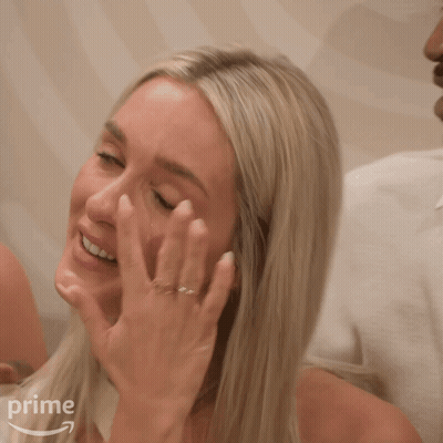 A Woman With A Ring On Her Finger Is Covering Her Face With Her Hand In Front Of A Prime Logo GIF