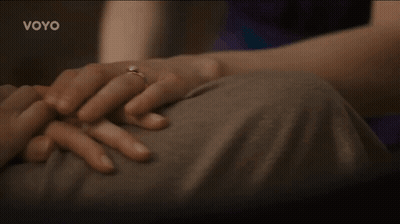 A Woman With A Ring On Her Finger Is Holding A Man 'S Hand With The Word Voyo On The Bottom GIF