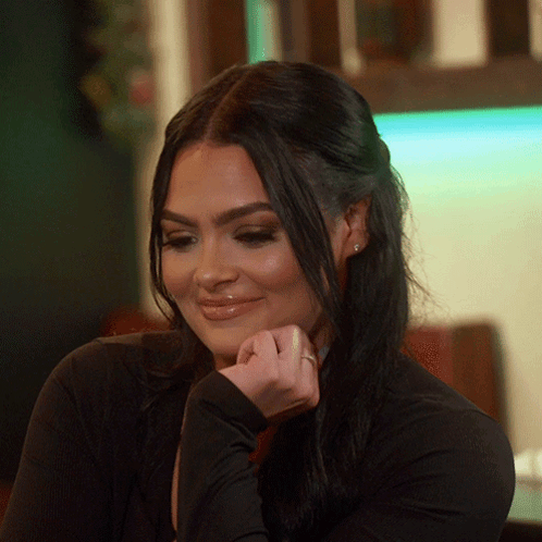 A Woman With A Ring On Her Finger Smiles For The Camera GIF
