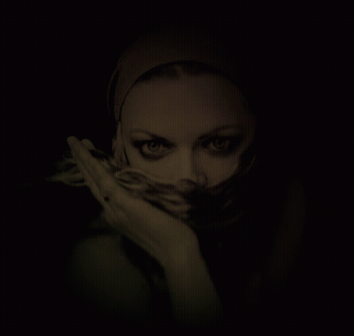 A Woman With A Scarf Around Her Face Looks At The Camera GIF