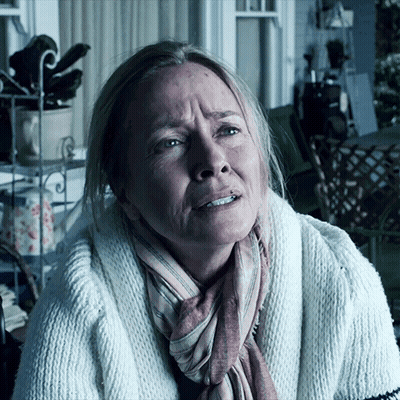 A Woman With A Scarf Around Her Neck And A White Sweater GIF