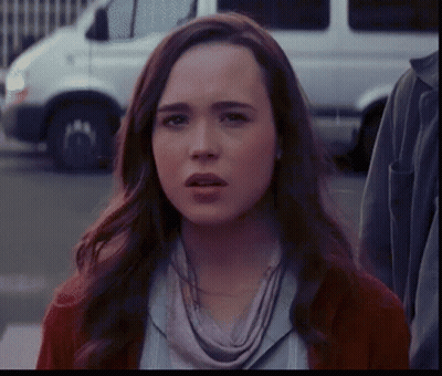 A Woman With A Scarf Around Her Neck Is Looking At The Camera GIF