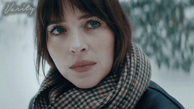 A Woman With A Scarf Around Her Neck Looks At The Camera With The Word Verity Below Her GIF