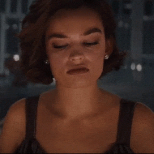 A Woman With A Serious Look On Her Face Wearing Earrings GIF