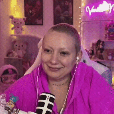 A Woman With A Shaved Head Is Sitting In Front Of A Microphone Wearing Headphones . GIF