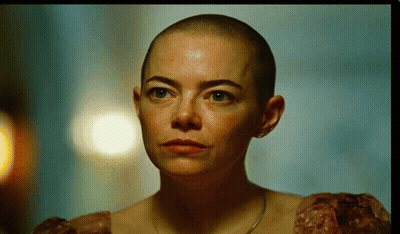 A Woman With A Shaved Head Is Wearing A Dress GIF
