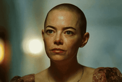 A Woman With A Shaved Head Is Wearing A Dress GIF