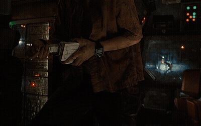 A Woman With A Shaved Head Looks At The Camera In A Dark Room GIF