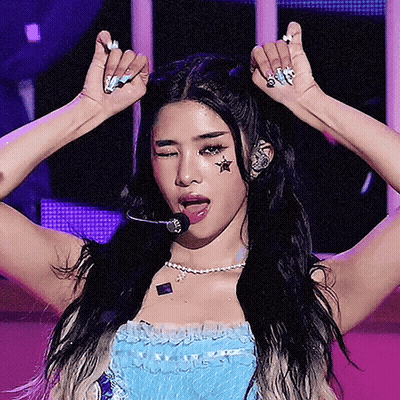 A Woman With A Star On Her Forehead Is Wearing A Microphone GIF