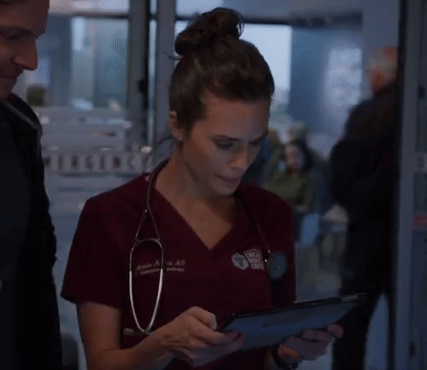 A Woman With A Stethoscope Around Her Neck Is Using A Tablet GIF