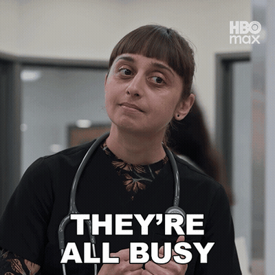 A Woman With A Stethoscope Around Her Neck Says They 'Re All Busy In White Letters GIF