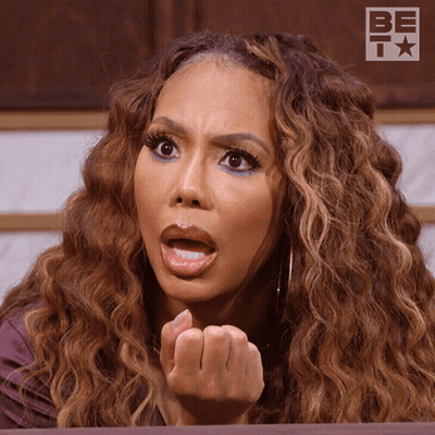 A Woman With A Surprised Look On Her Face Is Sitting In Front Of A Be T Logo GIF