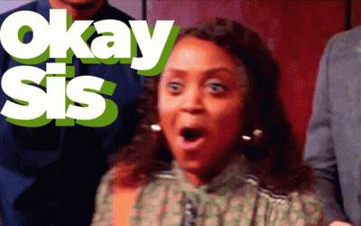 A Woman With A Surprised Look On Her Face Is Standing In Front Of Okay Sis GIF