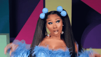A Woman With A Surprised Look On Her Face Is Wearing A Blue Feathered Top GIF