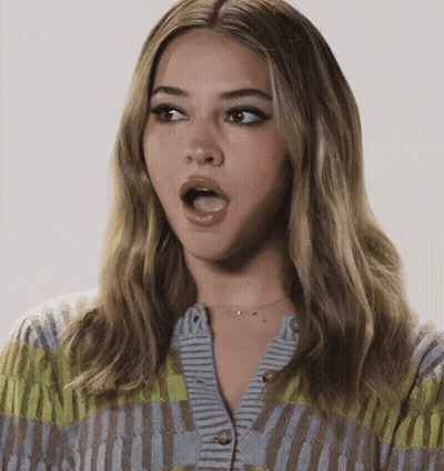 A Woman With A Surprised Look On Her Face Wearing A Cardigan GIF