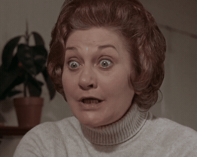 A Woman With A Surprised Look On Her Face Wearing A White Sweater GIF