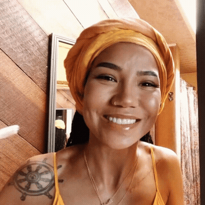 A Woman With A Tattoo Of A Steering Wheel On Her Shoulder Smiles GIF