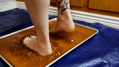 A Woman With A Tattoo On Her Ankle Is Standing On A Tray Of Liquid GIF