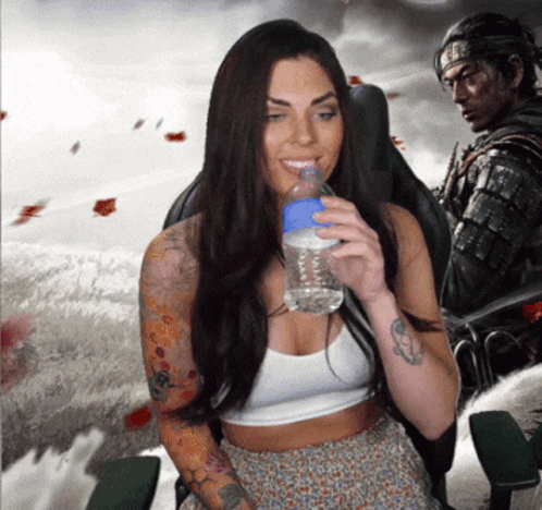 a woman with a tattoo on her arm drinks water from a blue bottle