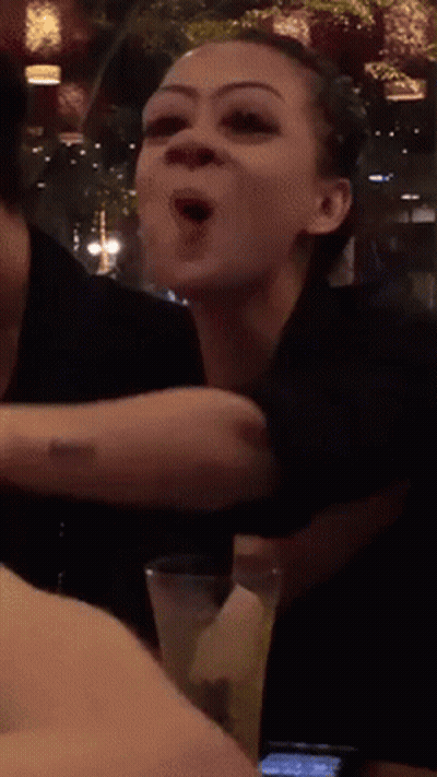 A Woman With A Tattoo On Her Arm Holds A Glass Of Water GIF