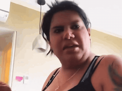 A Woman With A Tattoo On Her Arm Is Making A Face GIF