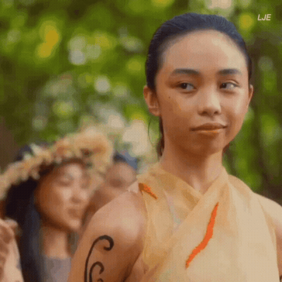 A Woman With A Tattoo On Her Arm Looks At The Camera With The Letters Lje Visible In The Corner GIF