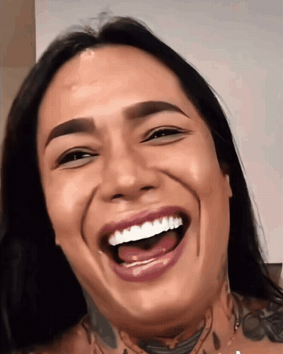 A Woman With A Tattoo On Her Neck Is Laughing With Her Mouth Wide Open GIF