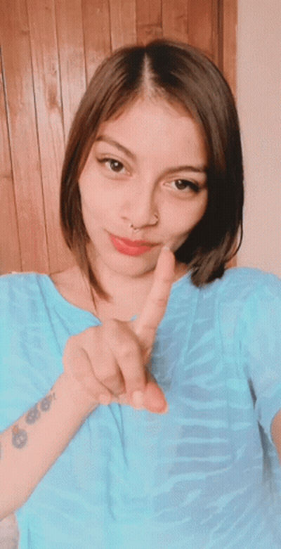 A Woman With A Tattoo On Her Wrist Giving A Peace Sign GIF