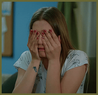 A Woman With A Tattoo On Her Wrist Is Covering Her Face GIF