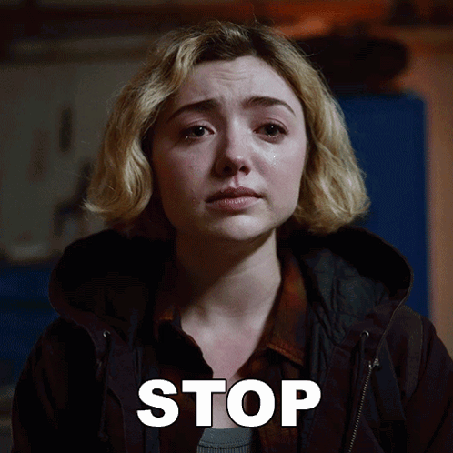 A Woman With A Tear Running Down Her Face Is Next To A Stop Sign GIF