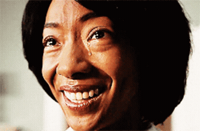 A Woman With A Tear Running Down Her Face Is Smiling GIF