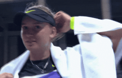 A Woman With A Towel Around Her Neck Is Wearing A Nike Hat GIF