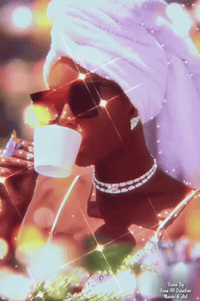 A Woman With A Towel Wrapped Around Her Head Drinks From A Cup GIF