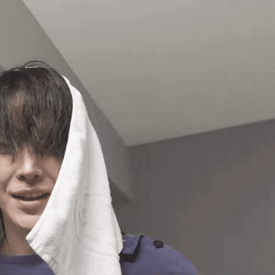 A Woman With A Towel Wrapped Around Her Head Is Smiling GIF