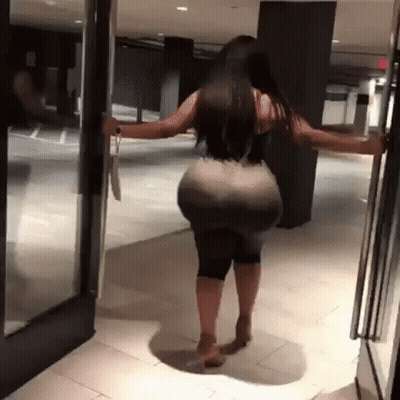 A Woman With A Very Large Butt Is Opening A Door . GIF