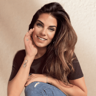 A Woman With An Infinity Tattoo On Her Wrist Smiles GIF