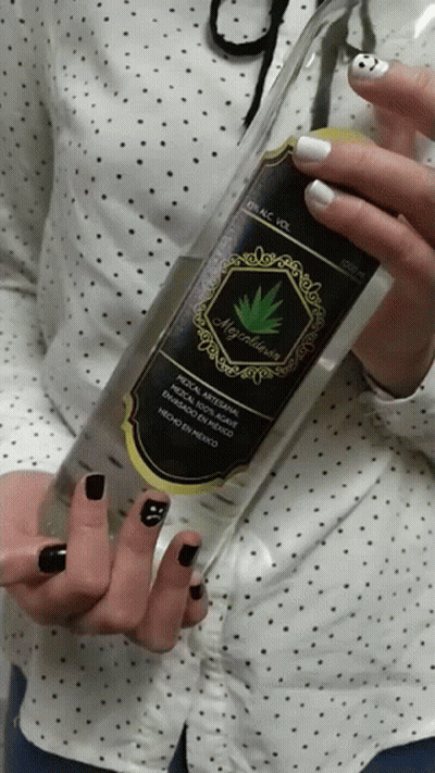 A Woman With Black Nails Holds A Bottle Of Alcohol GIF