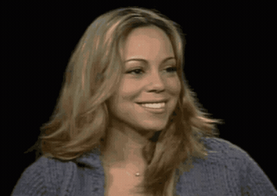 A Woman With Blonde Hair And A Blue Sweater Smiles GIF