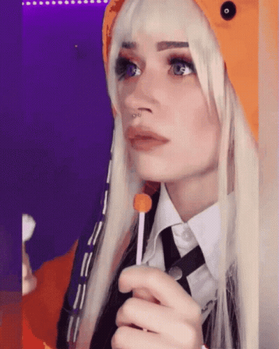 A Woman With Blonde Hair And A Nose Ring Holds A Lollipop In Her Hand GIF