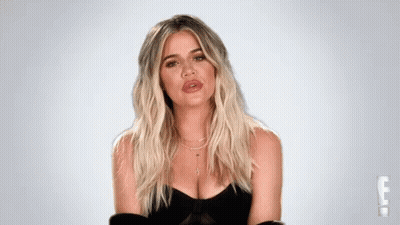 A Woman With Blonde Hair And A Plunging Neckline Is Wearing A Black Dress . GIF