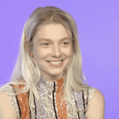 A Woman With Blonde Hair And A Striped Shirt Is Smiling GIF