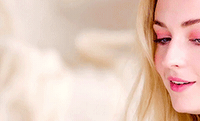 A Woman With Blonde Hair And Blue Eyes Is Smiling GIF