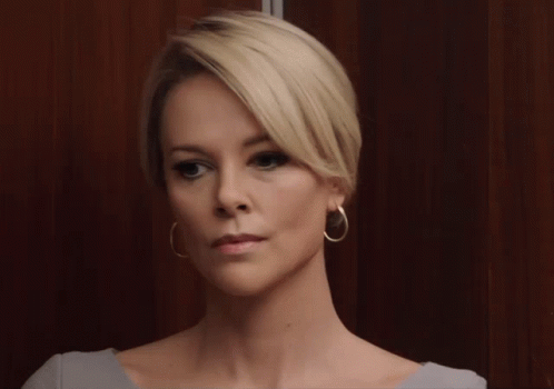 A Woman With Blonde Hair And Gold Hoop Earrings GIF