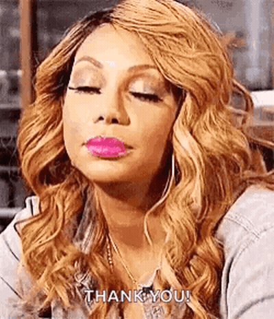 A Woman With Blonde Hair And Pink Lipstick Is Making A Funny Face . GIF