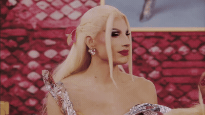 A Woman With Blonde Hair And Red Lipstick Is Wearing A Foil Dress GIF